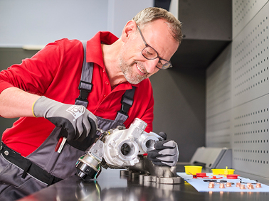 mechanic inspecting a turbocharger on a workbench