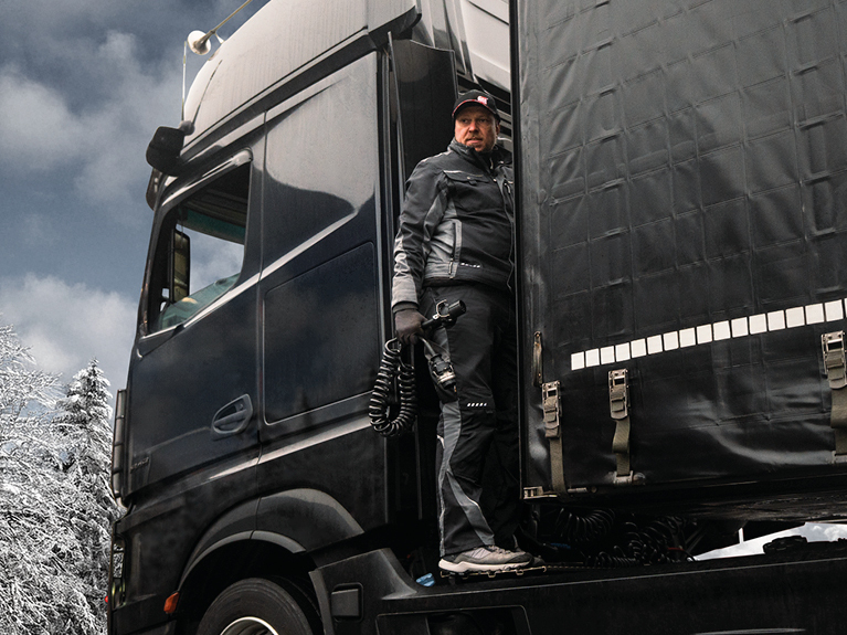 Un meccanico in un'officina vicino a un semirimorchio